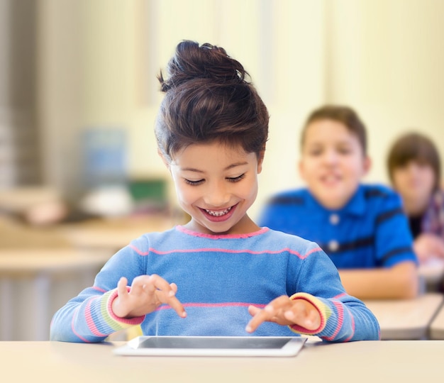 educação, escola primária, tecnologia e conceito de crianças - menina estudante feliz com tablet pc sobre fundo de sala de aula e colegas