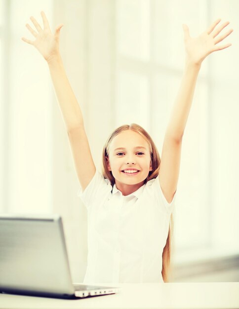 educação, escola, tecnologia e conceito de internet - menina feliz com laptop pc na escola