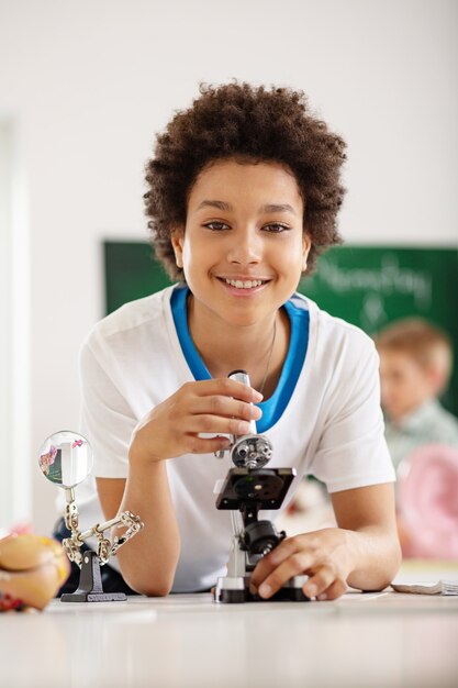 Educação escolar. Bom garoto encantado tendo uma aula de biologia enquanto estudava na escola