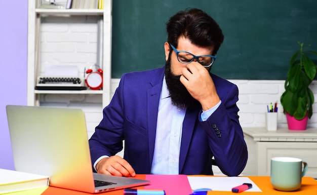 Educação estressou estudante cansado se preparando para teste ou exame em fadiga em sala de aula após longo laptop