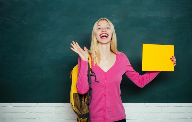 Educação formal. melhorando a mim mesmo por meio da educação. garota feliz segurando o anúncio enquanto estiver na sala de aula. aluno com mochila. ensino médio. grande oportunidade. procurando por voluntários