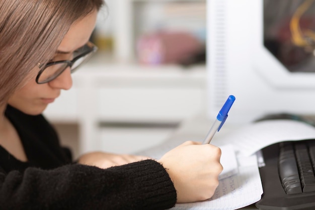 Educação on-line em casa Jovem adolescente em casa estuda, escreve, lê, lembra