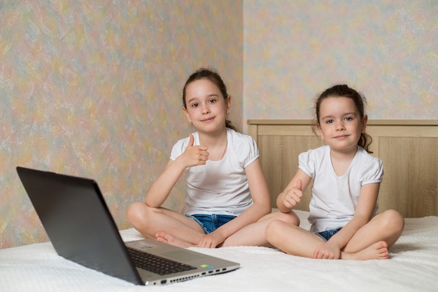 Educação online a distância. Colegial e sua irmã estudando em casa com notebook laptop tablet digital