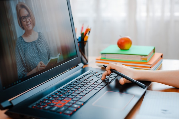 Educação online a distância. um menino estuda em casa e faz as tarefas da escola. um ensino à distância em casa