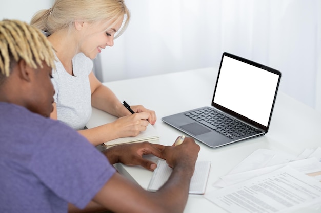 Educação online estudando maquete digital de casal sorrindo mulher e homem negro fazendo anotações em