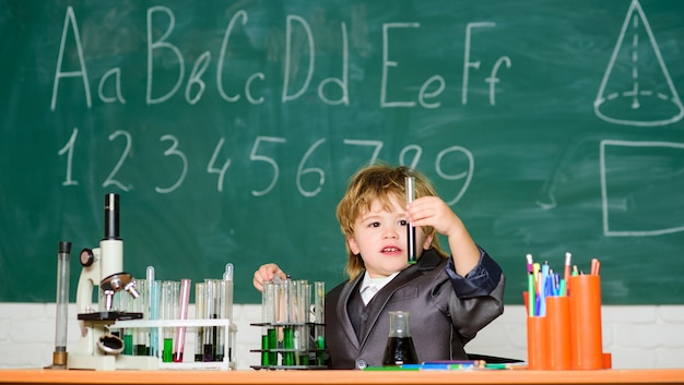 Educação primária de conhecimentos básicos. Criança estudar química de biologia. Experiência educacional. Infância feliz. Menino perto da sala de aula da escola de microscópio e tubos de ensaio. Conceito de conhecimento. Dia do conhecimento.