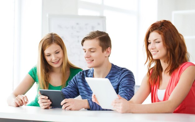 educação, tecnologia e conceito de internet - alunos sorridentes com computadores tablet pc na escola