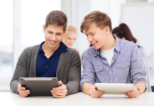 Educação, tecnologia e internet - dois alunos sorridentes olhando para o tablet pc em palestra na escola