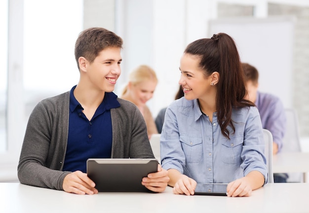 educação, tecnologia e internet - dois alunos sorridentes olhando para o tablet pc em palestra na escola