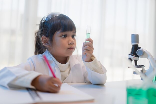 educación ciencia química y niños concepto niños o estudiantes con tubo de ensayo haciendo experimento en el laboratorio de la escuela