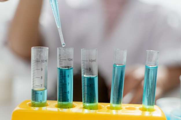 Educación ciencia química y niños concepto niños o estudiantes con tubo de ensayo haciendo experimentos en el laboratorio escolar