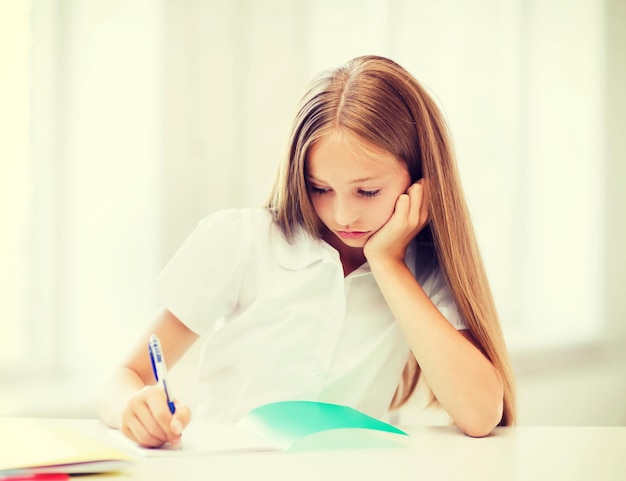 educación y concepto escolar - niña estudiante que estudia en la escuela