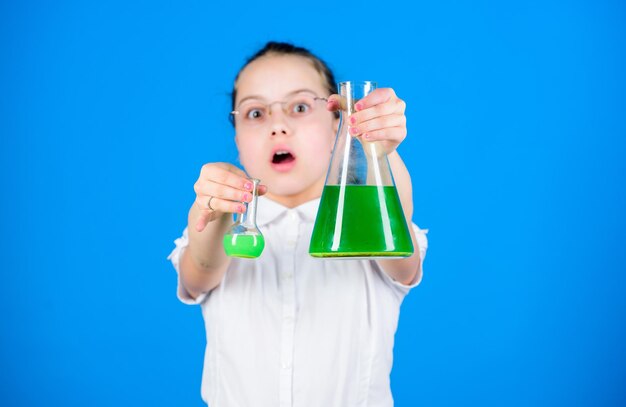 Foto educación y conocimiento. de vuelta a la escuela. lección de biología de estudio infantil. pequeña chica inteligente con matraz de prueba. investigación científica en el laboratorio. colegiala pequeña. confiada en sus investigaciones.