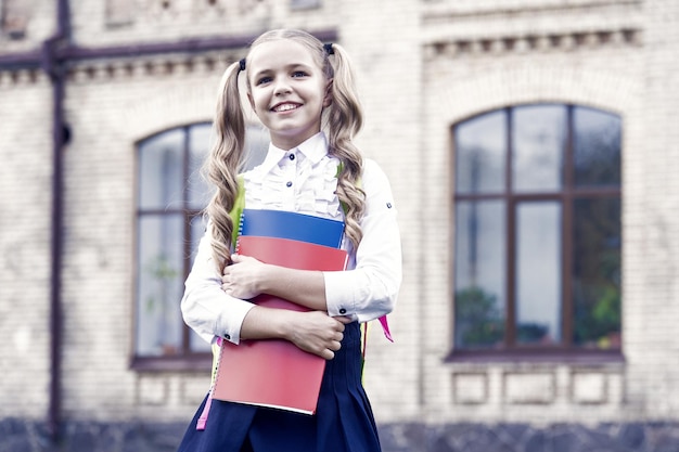 La educación desarrolla la nación, la niña pequeña sostiene la literatura del libro para los niños.