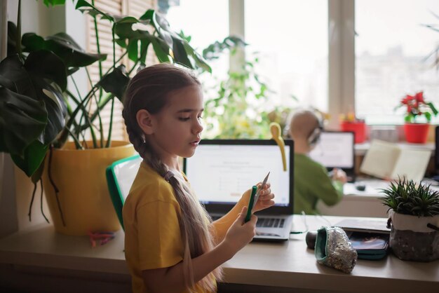 Educación a distancia en casa dos hermanos haciendo la tarea juntos en una habitación encerrada nueva normalidad