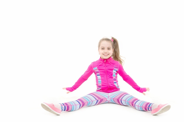 Educación y energía. Condición física y salud. Deporte y éxito. Niño con ropa deportiva rosa. Entrenamiento de niña pequeña aislado sobre fondo blanco.