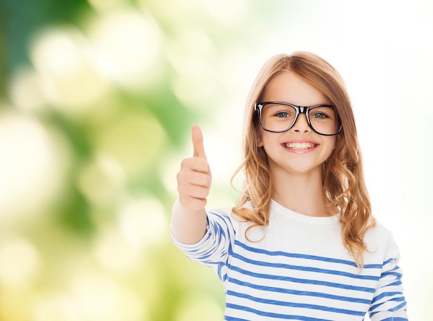 educación, escuela y concepto de visión - niñita linda y sonriente con anteojos negros mostrando gesto de aprobación