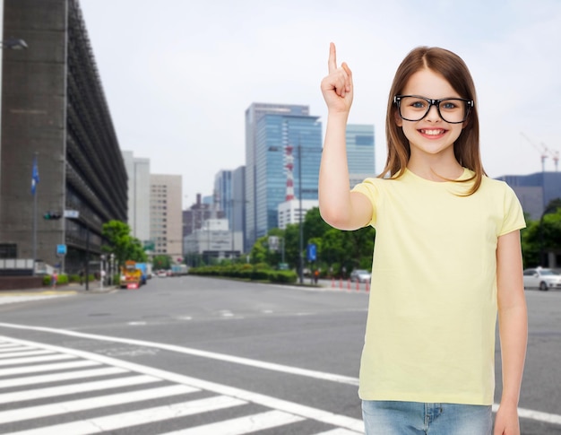 educación, escuela y concepto de visión - niñita linda y sonriente con anteojos negros