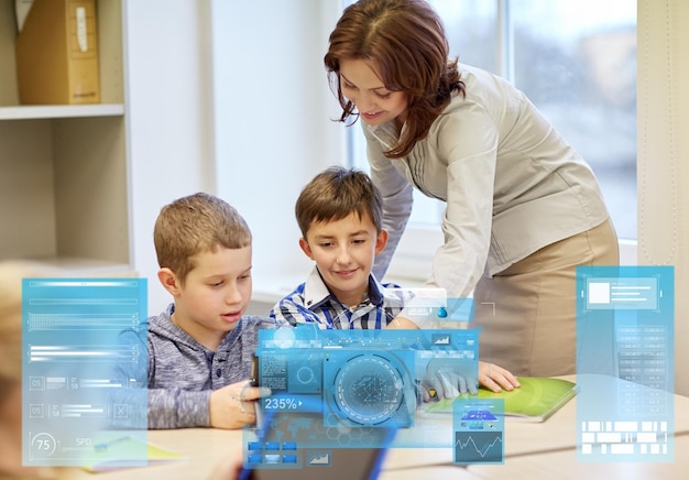 Foto educación, escuela primaria, aprendizaje y concepto de personas: maestro que ayuda a los niños con una tableta en el aula a través de proyecciones de pantallas virtuales