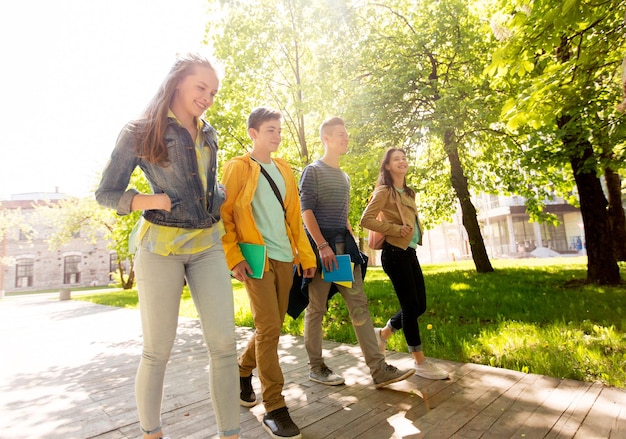 educación, escuela secundaria, aprendizaje y concepto de personas - grupo de estudiantes adolescentes felices caminando al aire libre
