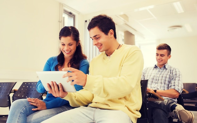 educación, escuela secundaria, trabajo en equipo y concepto de personas - grupo de estudiantes sonrientes con tabletas que hacen fotos o videos en la sala de conferencias