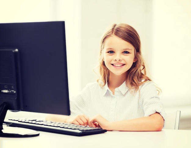 educación, escuela, tecnología y concepto de internet - niña estudiante con computadora en la escuela