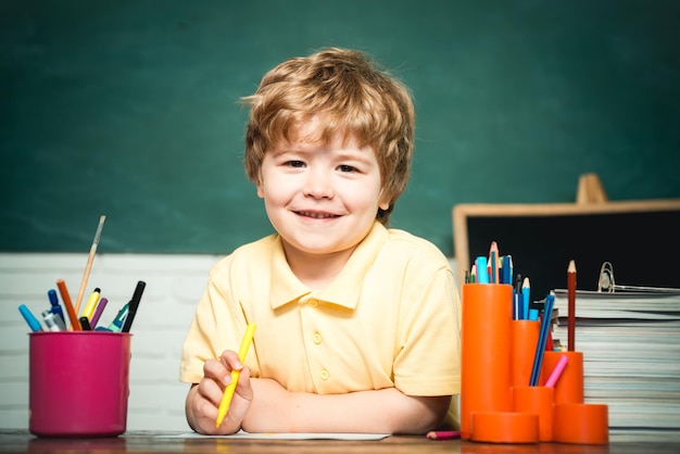 Educación en el hogar o en la escuela Niño de retrato de la escuela primaria Alumno de la escuela primaria en el patio de la escuela Niño sonriente alegre en la pizarra