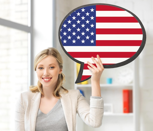 educación, idioma extranjero, inglés, gente y concepto de comunicación - mujer sonriente sosteniendo una burbuja de texto de bandera estadounidense