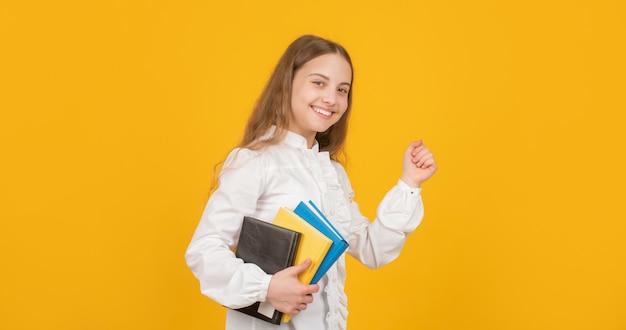 Educación Infantil. día del conocimiento. niño sostenga el cuaderno. estudiante en la escuela secundaria. chica adolescente hacer la tarea con el cuaderno. estudiar con el libro de trabajo. niño alegre correr con libro. De vuelta a la escuela.