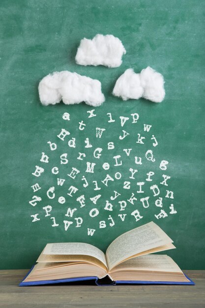 Educación y lectura concepto creativo lluvia de letras cae en un libro abierto inspiración para escribir un cuento de hadas