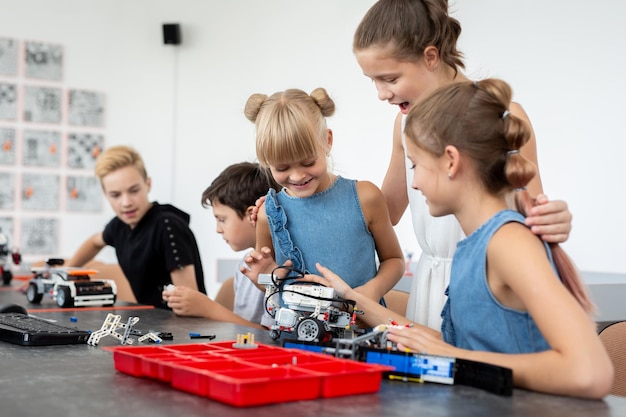 Educación niños tecnología ciencia y personas concepto grupo de niños felices con computadora portátil