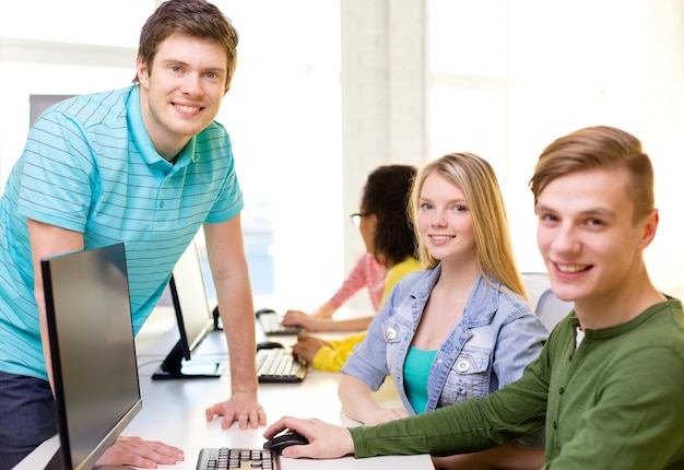 educación, tecnología y concepto escolar - grupo de estudiantes sonrientes en clase de computación