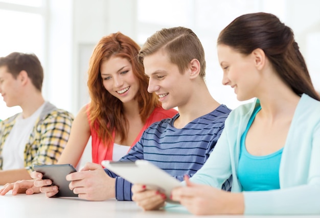 educación, tecnología y concepto de internet - estudiantes sonrientes con tabletas en la escuela