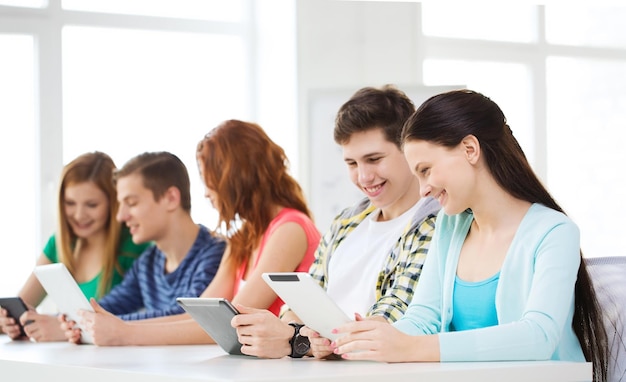 Foto educación, tecnología y concepto de internet - estudiantes sonrientes con tabletas en la escuela