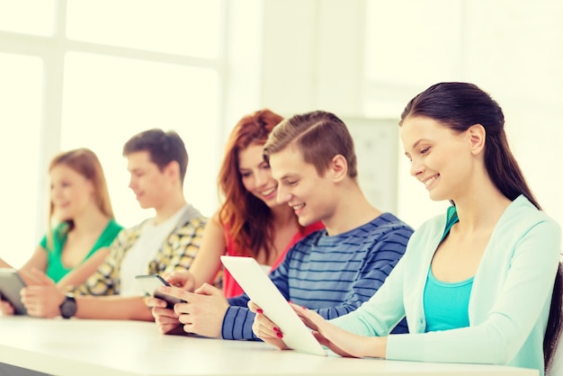 educación, tecnología y concepto de internet - estudiantes sonrientes con tabletas en la escuela