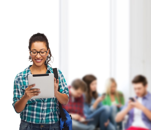 educación, tecnología y concepto de personas - estudiante afroamericana sonriente en anteojos con tablet pc y bolsa