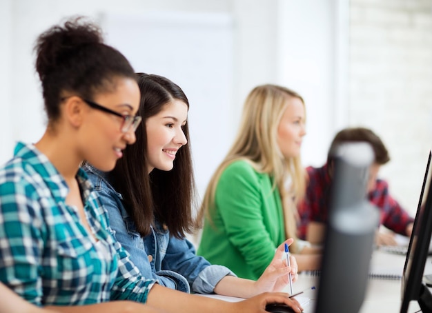 educación, tecnología e internet: estudiantes con computadoras que estudian en la escuela