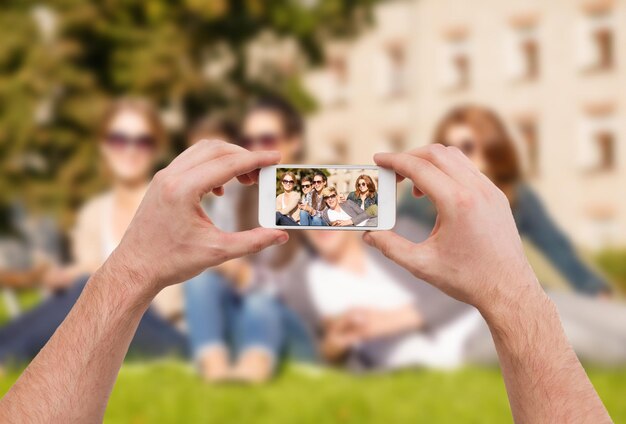 educación, tecnología, vacaciones de verano y concepto adolescente - cierre de manos haciendo una foto de un grupo de adolescentes