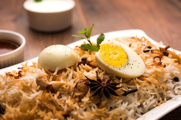 Egg biryani - arroz basmati cozido com ovos assados masala e temperos e servido com iogurte, foco seletivo
