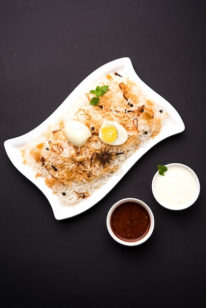 Egg Biryani - Basmatireis gekocht mit Masala gerösteten Eiern und Gewürzen und serviert mit Joghurt, selektiver Fokus