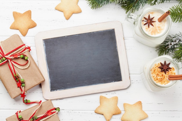 Foto eggnog traditioneller weihnachtscocktail und lebkuchen auf einem hölzernen tisch flach gelegene top-ansicht mit tafel für ihre grüße