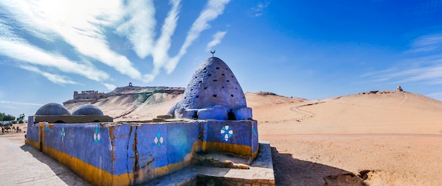 Egipto, en el Alto Egipto, Asuán, Mausoleo de la Colmena pintada de azul con la Tumba de los Nobles en la cima de la colina detrás.