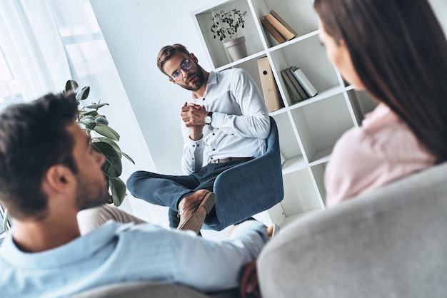 Ehe retten. Junges Ehepaar hört Psychologen beim Sitzen in der Therapiesitzung