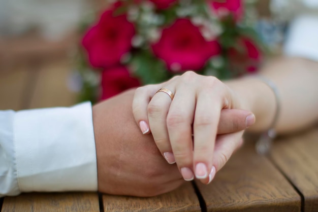 Ehe und Liebe Männliche und weibliche Hand mit einem Ehering