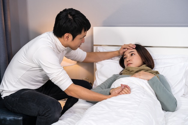 Ehemann besucht und kümmert sich um seine kranke Frau, während sie zu Hause im Bett liegt