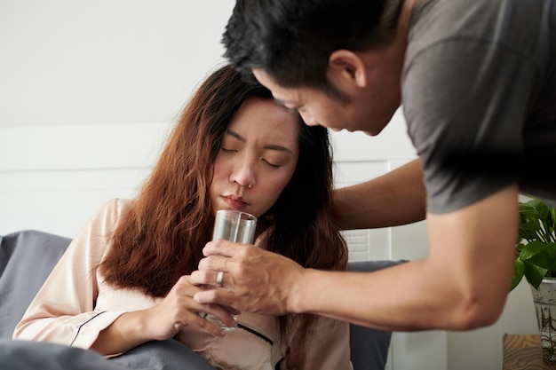 Ehemann gibt Ehefrau ein Glas Wasser