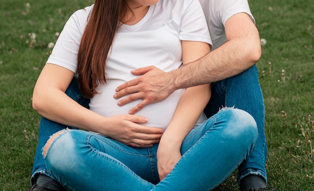 Ehemann Hände auf Bauch der schwangeren Frau außerhalb