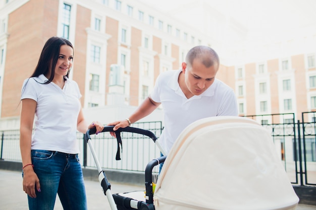 Ehepaar auf Spaziergang mit Kinderwagen.