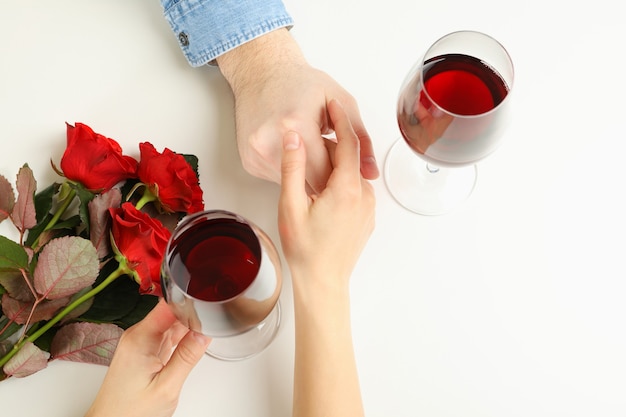 Ehepaar Hände, Wein und Rosen auf weißem Hintergrund