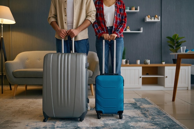 Ehepaar mit Koffern im Wohnzimmer. Touristen vor Reiseantritt